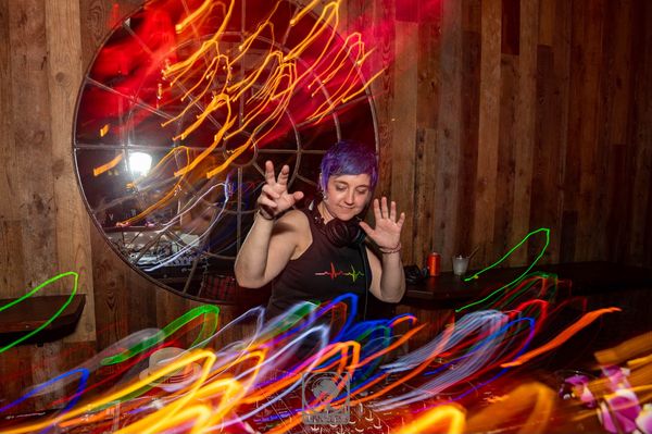 Jen Woolfe waving from the decks amid streaks of colored light