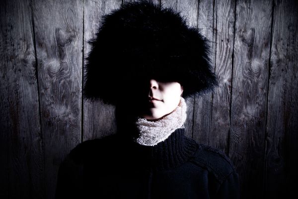 Dramatic portrait of Jen Woolfe with her face shadowed by a dark fur hat